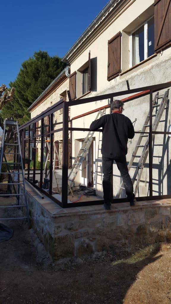 Travail de pose de la véranda sur une maison ancienne